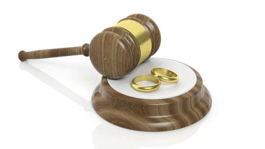 Gavel and two gold wedding bands symbolizing divorce